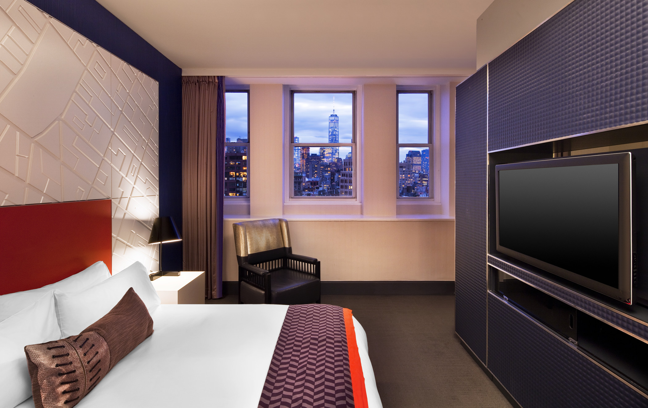 flat screen TV and bed with city view