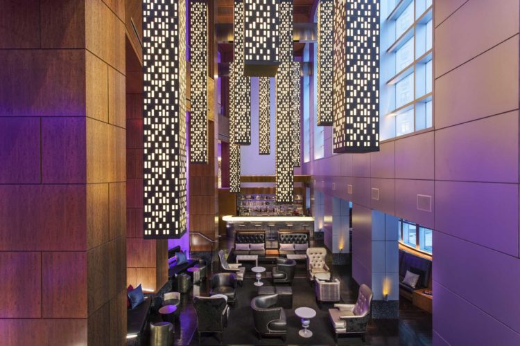 overhead view of modern luxury hotel bar with tall lighting fixtures hanging from ceiling